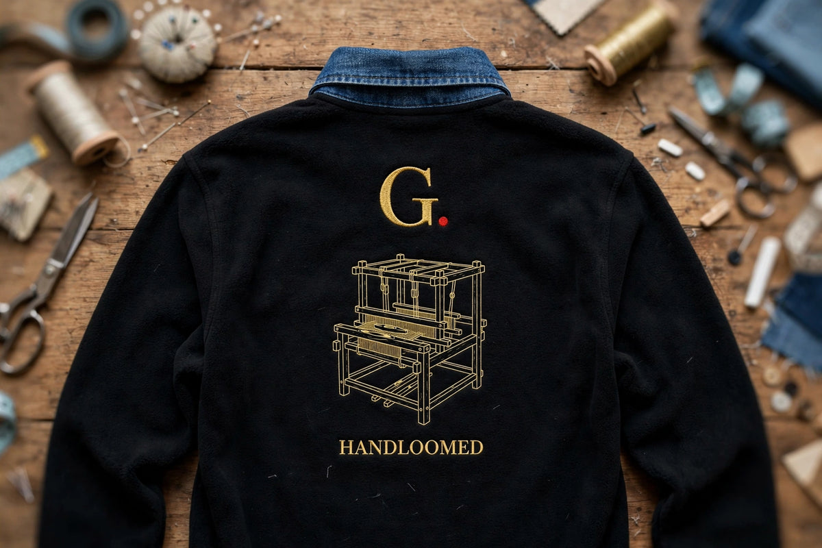 Back view: black fleece shirt with denim collar, gold G. logo, handloom embroidery and HANDLOOMED text